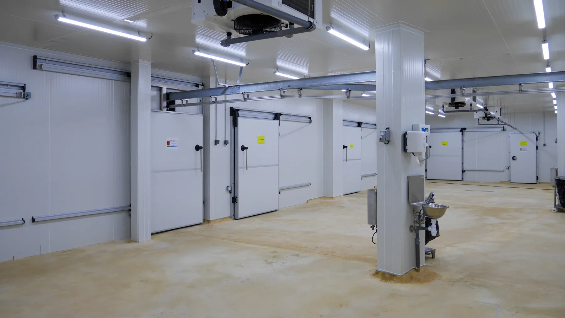 Le laboratoire de découpe : murs en panneaux isothermes blancs, rails au plafond, portes des chambres froides